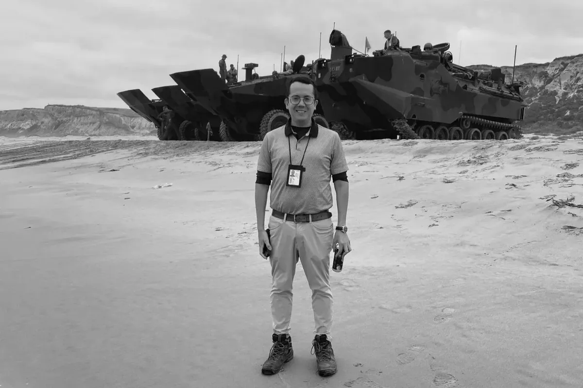 Johannes standing on a beach in front of an amphibious assault vehicle